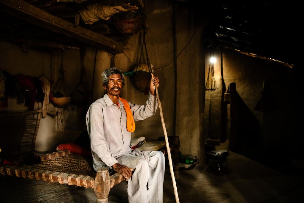 Mand i lerhytte i Nepal med solcellelampe fra nødhjælp