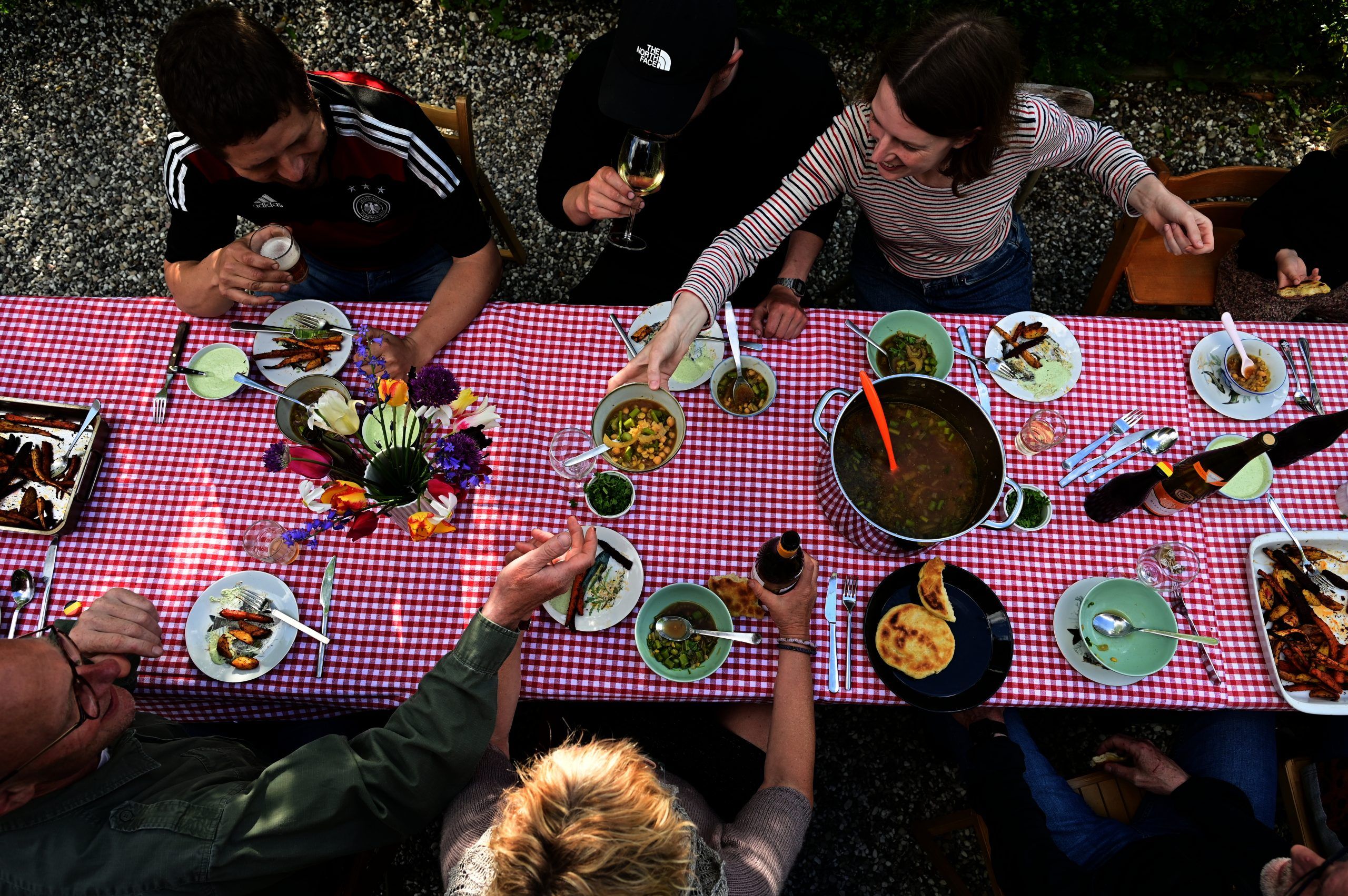 Folk spiser mad omkring et bord - illustration til Folkekirkens Nødhjælps fællesspisninger