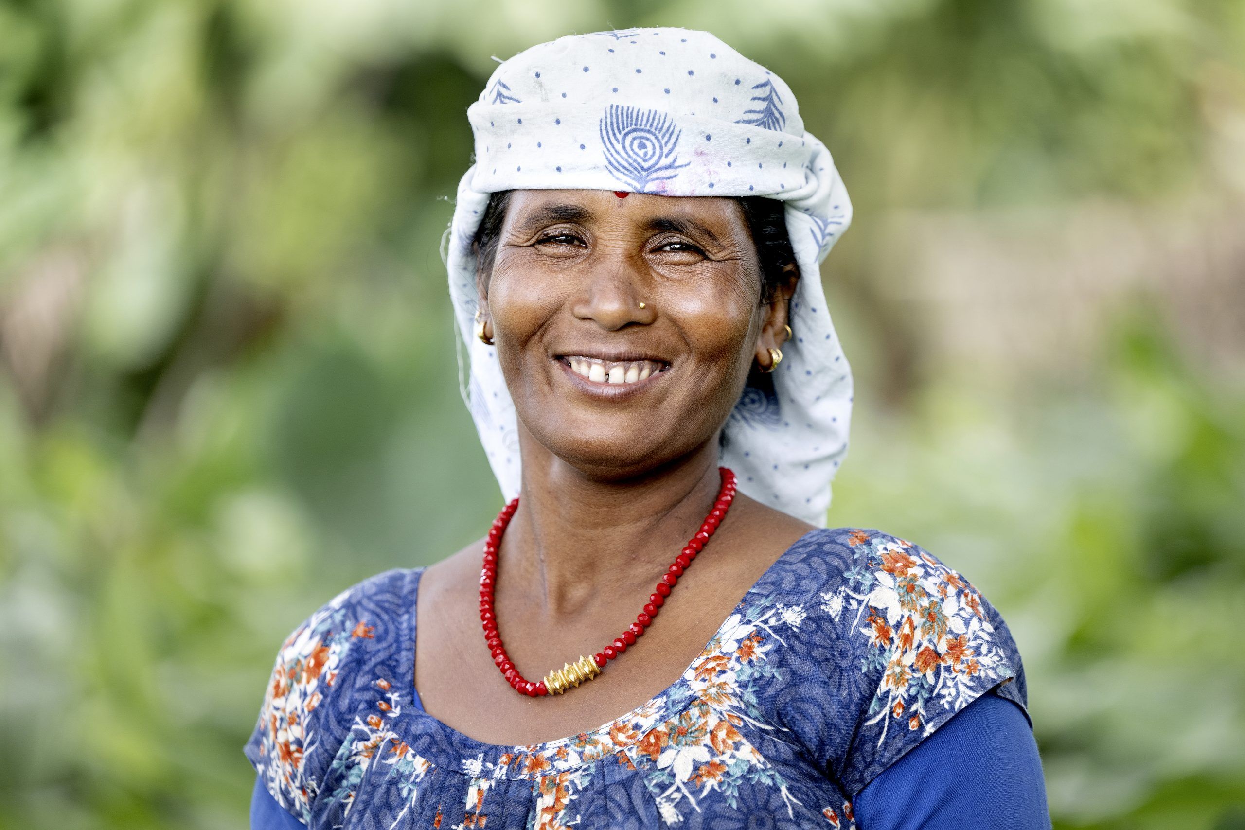 Smilende kvinde, der har modtaget fisk af Folkekirkens Nødhjælp