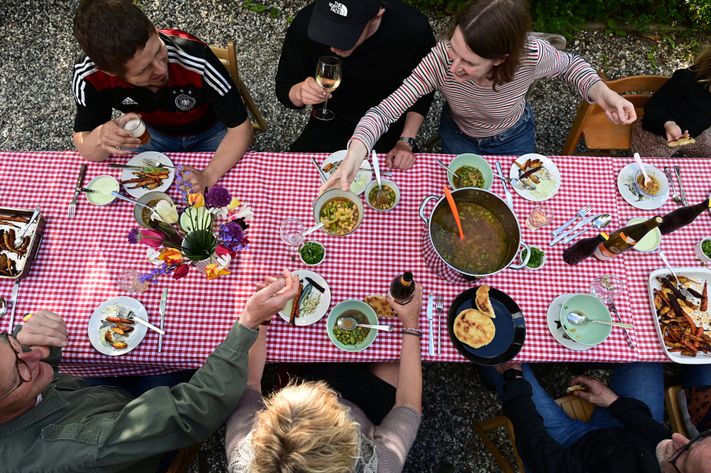 Mennesker samlet omkring et dækket bord til fællesspisning