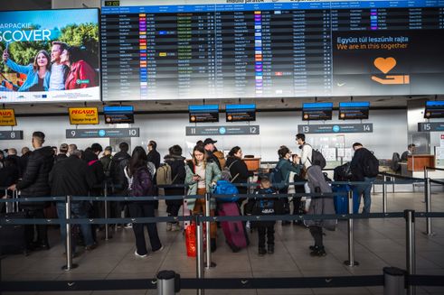 Familie venter på at checke deres baggage ind i lufthavn i Budapest