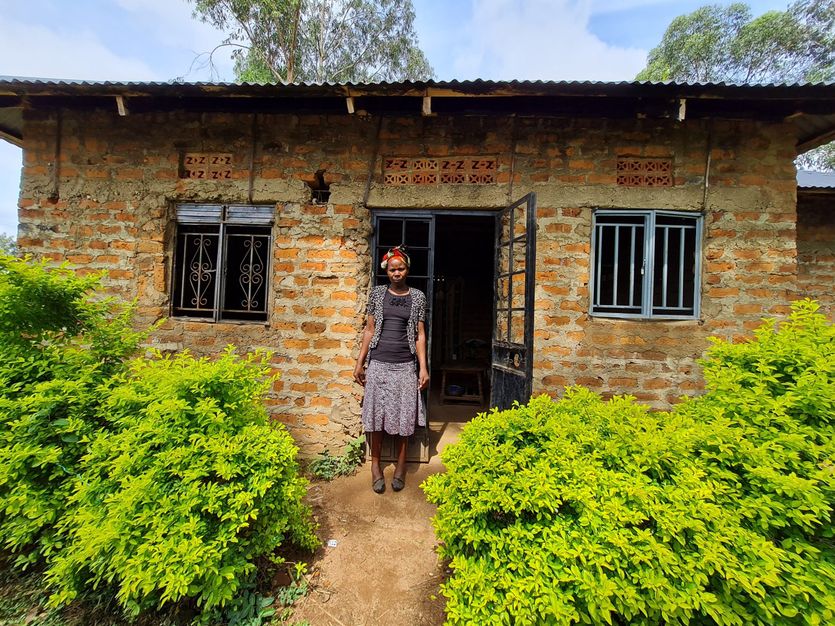 Celestine Amanai in front of her new house