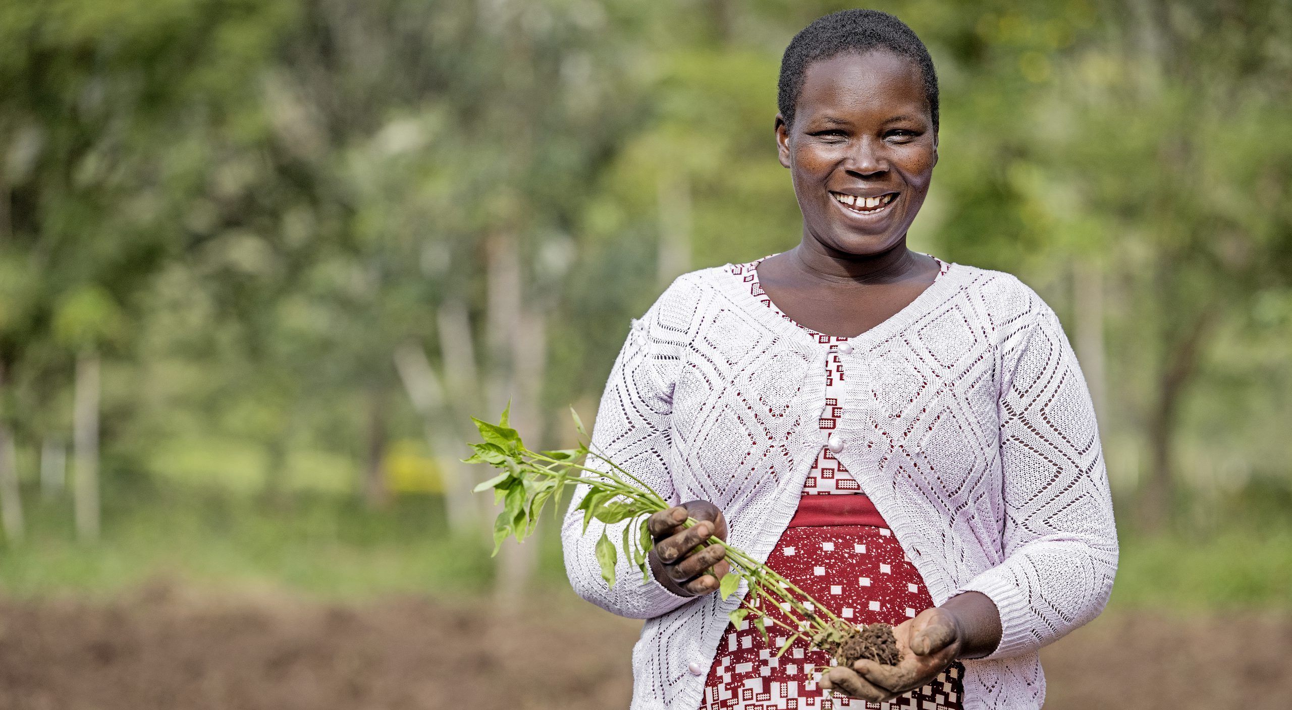 Smilende kvinde med afgrøder i hånden