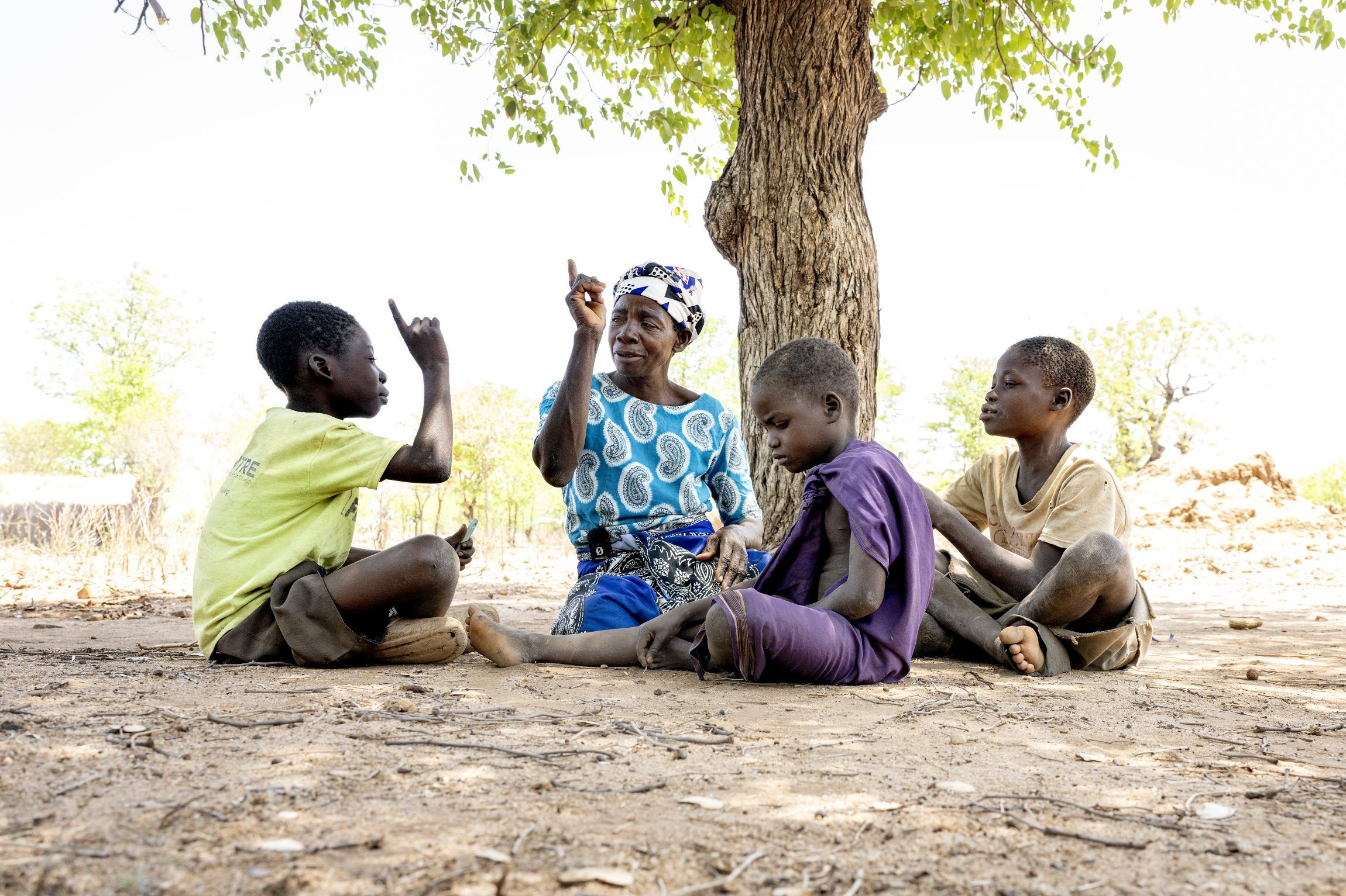Fatima sitting in the ground with children in Malawi