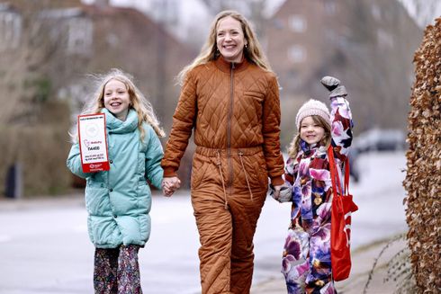 To piger og deres mor smiler mens de samler ind til Folkekirkens Nødhjælps Indsamling 2022