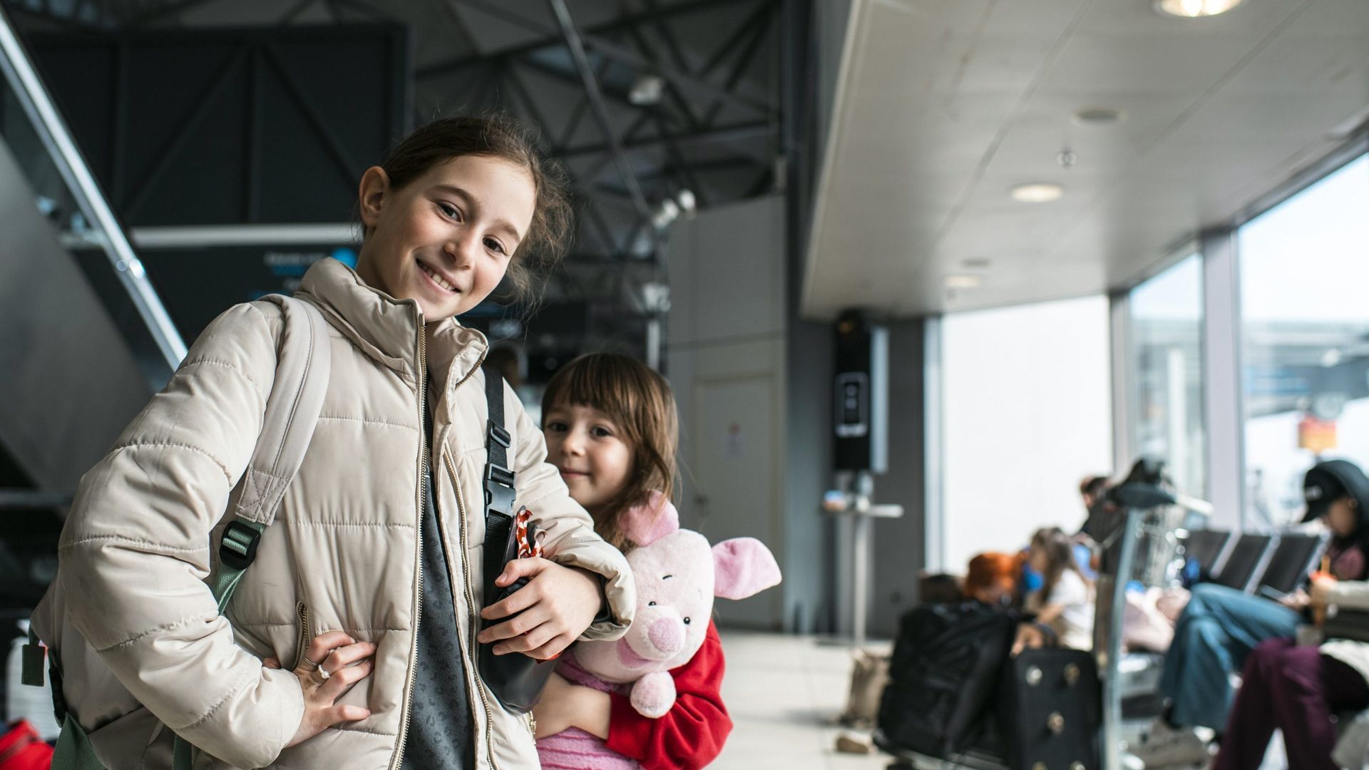 To piger smiler til kameraet i Budapest Lufthavn