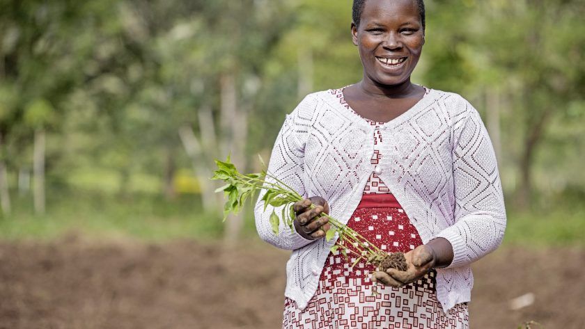 Smilende kvinde med afgrøder i hånden