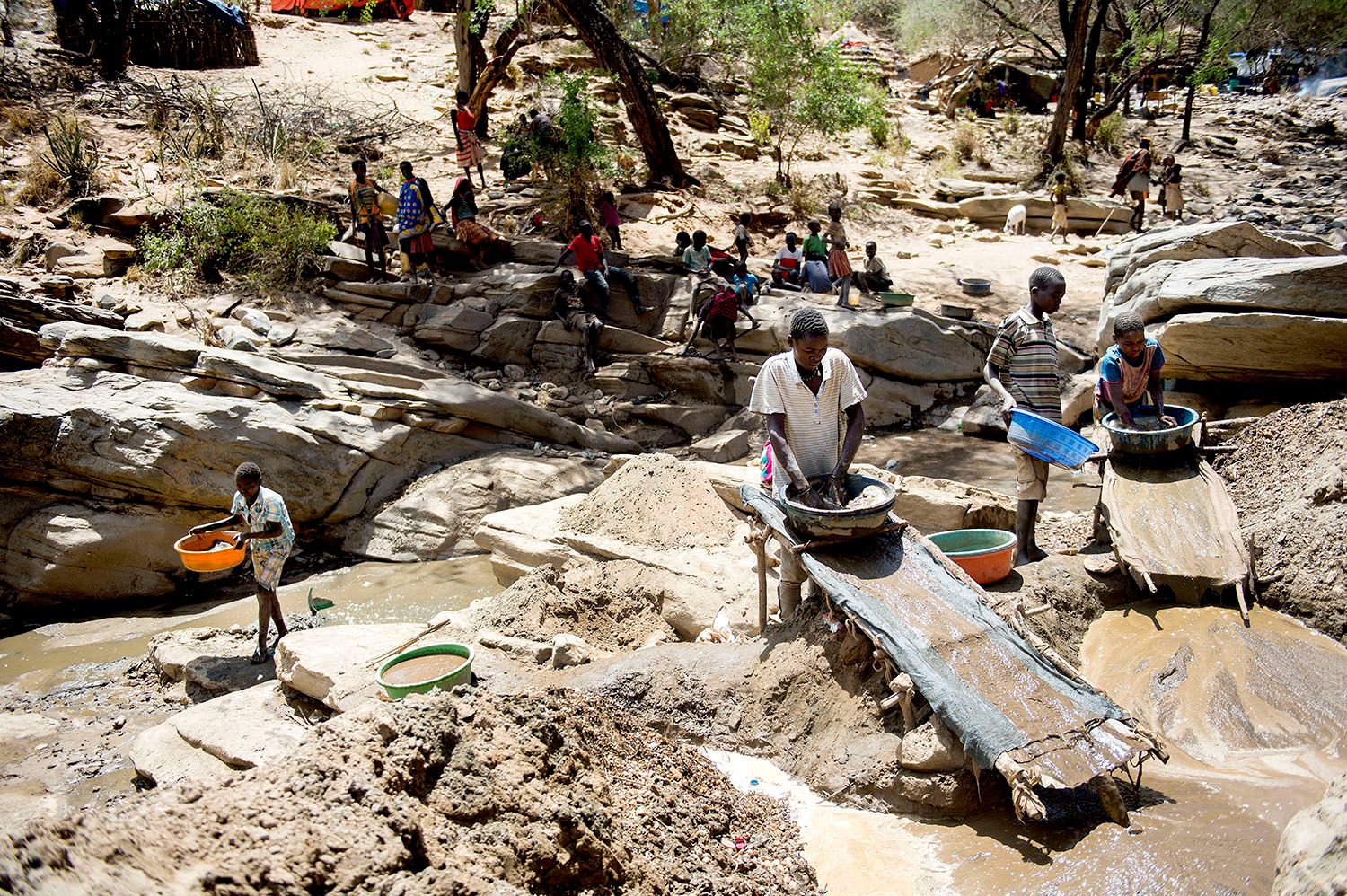 Drenge i Uganda vasker guld i en guldgraverlejr