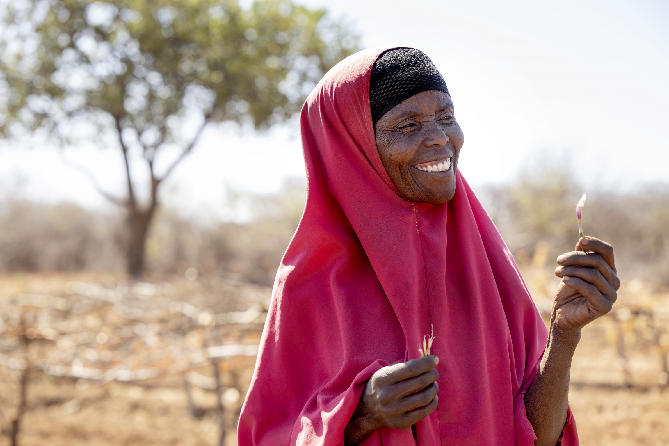 The woman Rabla from Ethiopia is happy. She holds af sprout in her hand.