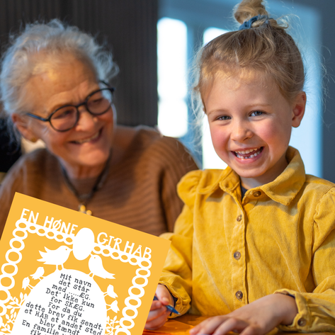 Barnebarn og bedstemor sidder sammen om årets gækkebrev fra Folkekirkens Nødhjælp