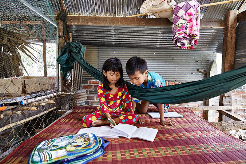 Bopha, en lille pige fra fra Cambodja, læser sammen en ven.