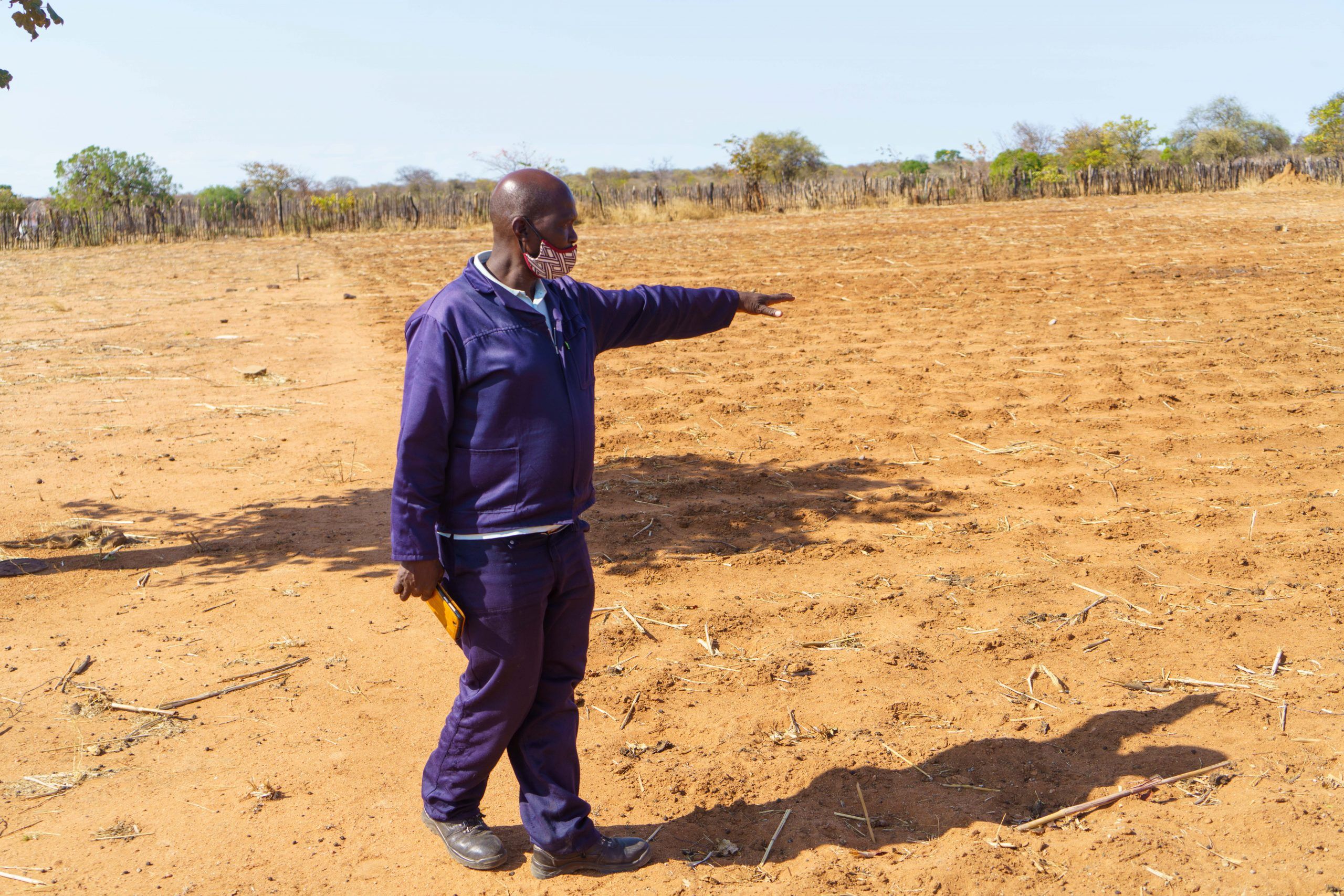 En landmand peger ud på marken i Matobo distriktet, Zimbabwe