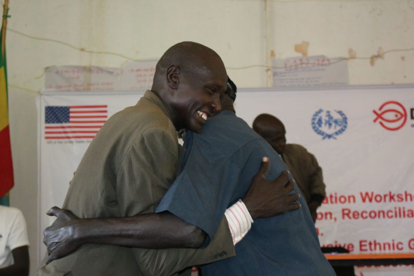 In a powerful display of leading by example, Obang Ogud invites his refugee friend Tut Riki to the front of the room and warmly embraces him with a hug. Through this simple yet profound gesture, Obang emphasizes the essence of coexistence and the celebration of diversity.