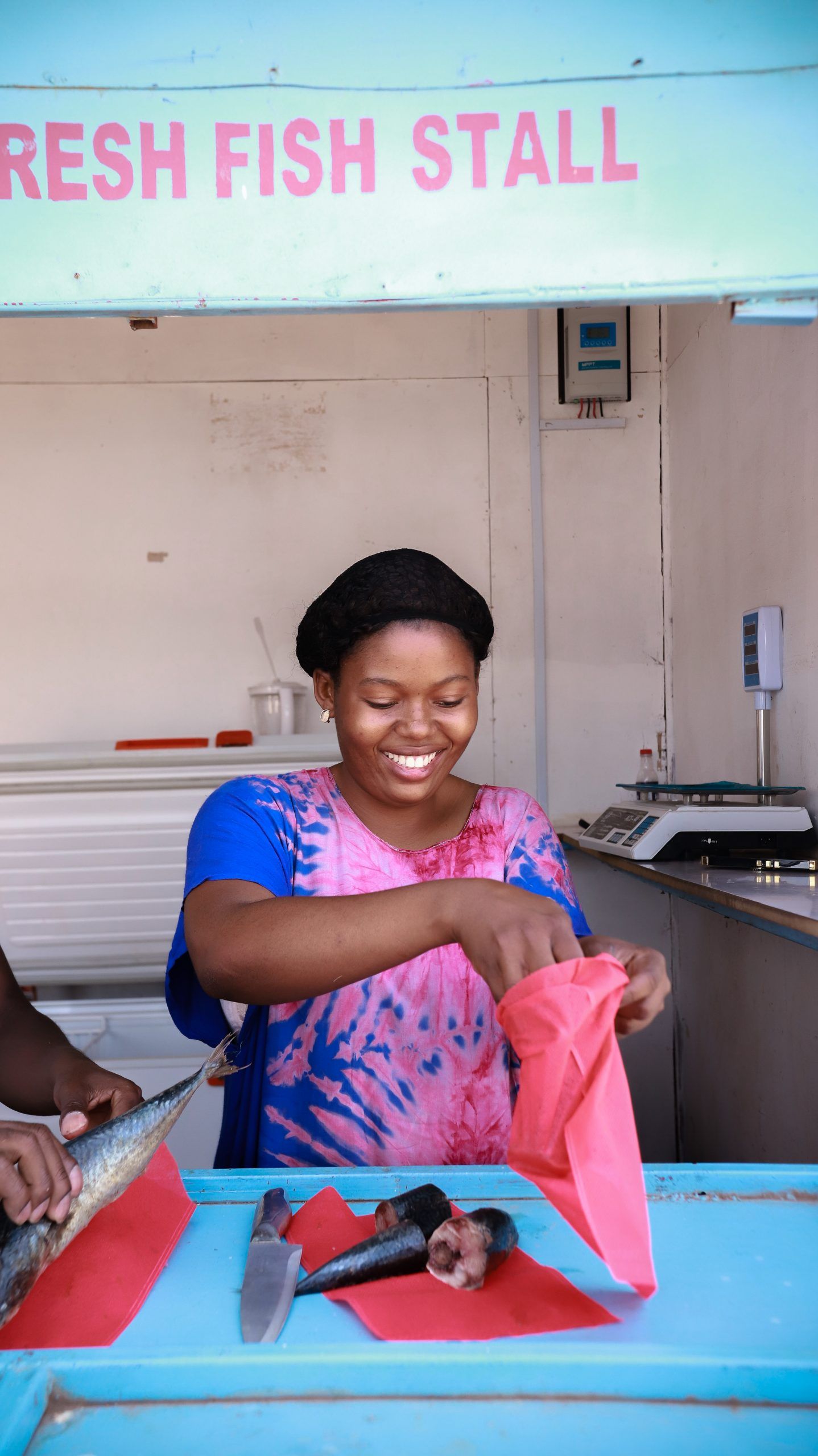 Young women preparing to sell fish in her fish stall.