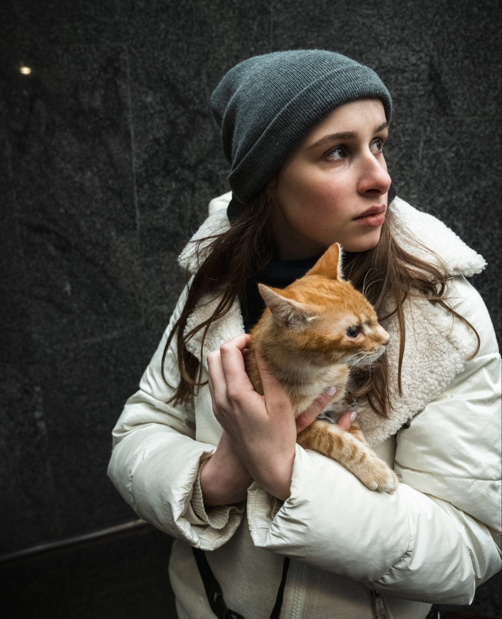 En ung ukrainsk kvinde står med sin kat i armene.