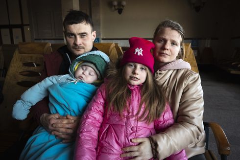 Mor og far med deres 2 børn på en togstation i Lviv, Ukraine.