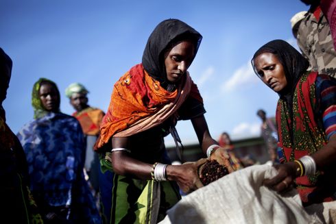 Kvinde modtager månedlig nødhjælp bestående af bønner, tørret majs og madolie