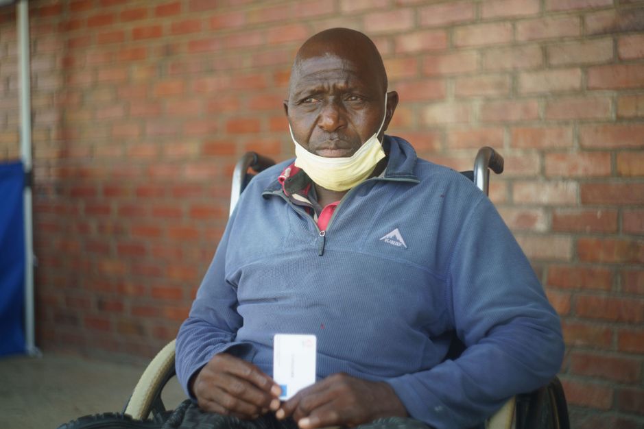 David Nkala, som er begunstiget af Multi-Purpose Cash Transfer, sidder på sin kørestol efter at have handlet med e-voucher-kort i Cowdray Park, Bulawayo, Zimbabwe.